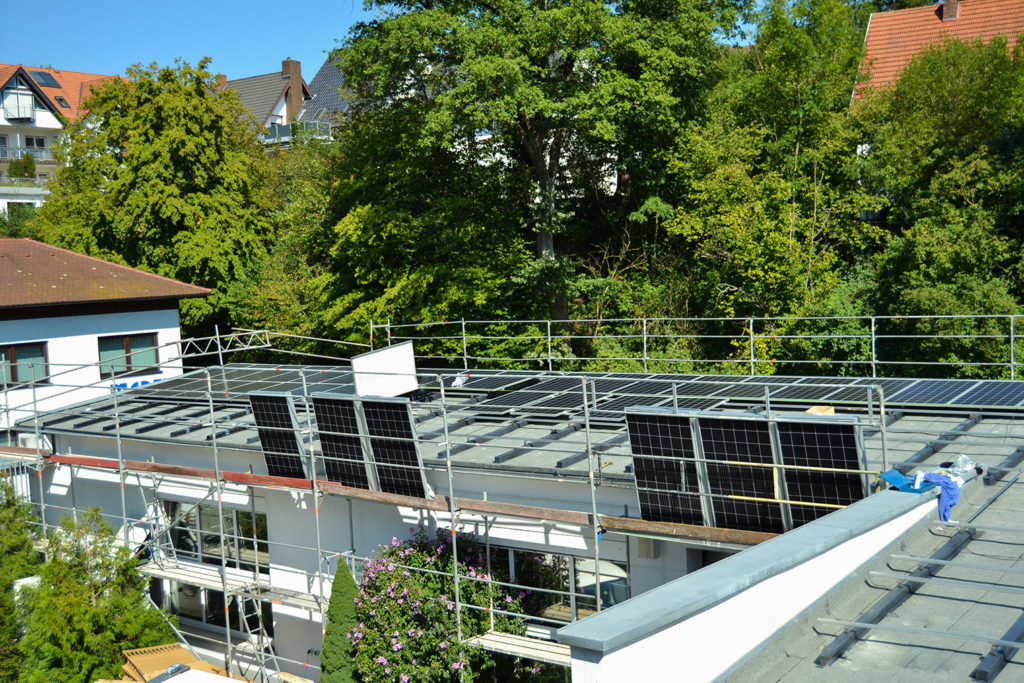 Photovoltaik-Kollektoren werden auf Dach montiert - betrieblicher Umweltschutz
