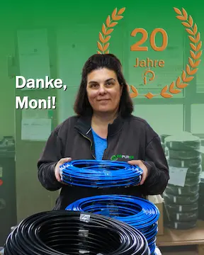Stellen_in_Mörlenbach_Moni Frau mit Schlauchring in der Hand. 20 Jahre Symbol im Hintergrund anlässlich des Jubiläums ihrer Stelle in Mörlenbach.