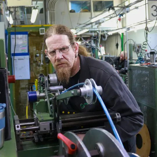 Ein Mitarbeiter ist während des Überwachungsaudit voll fokussiert auf einen Schlauch.