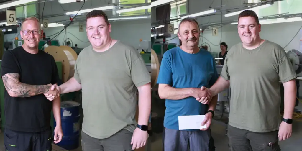 Zwei Mitarbeiter bekommen zu ihrem Betriebsjubiläum ein Geschenk überreicht.